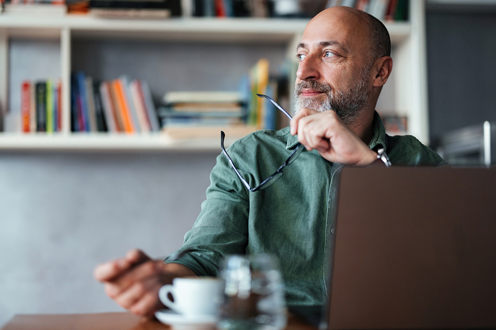 Man on laptop thinking.