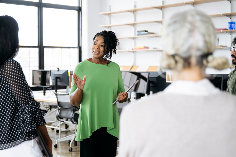 A woman talking to two colleagues